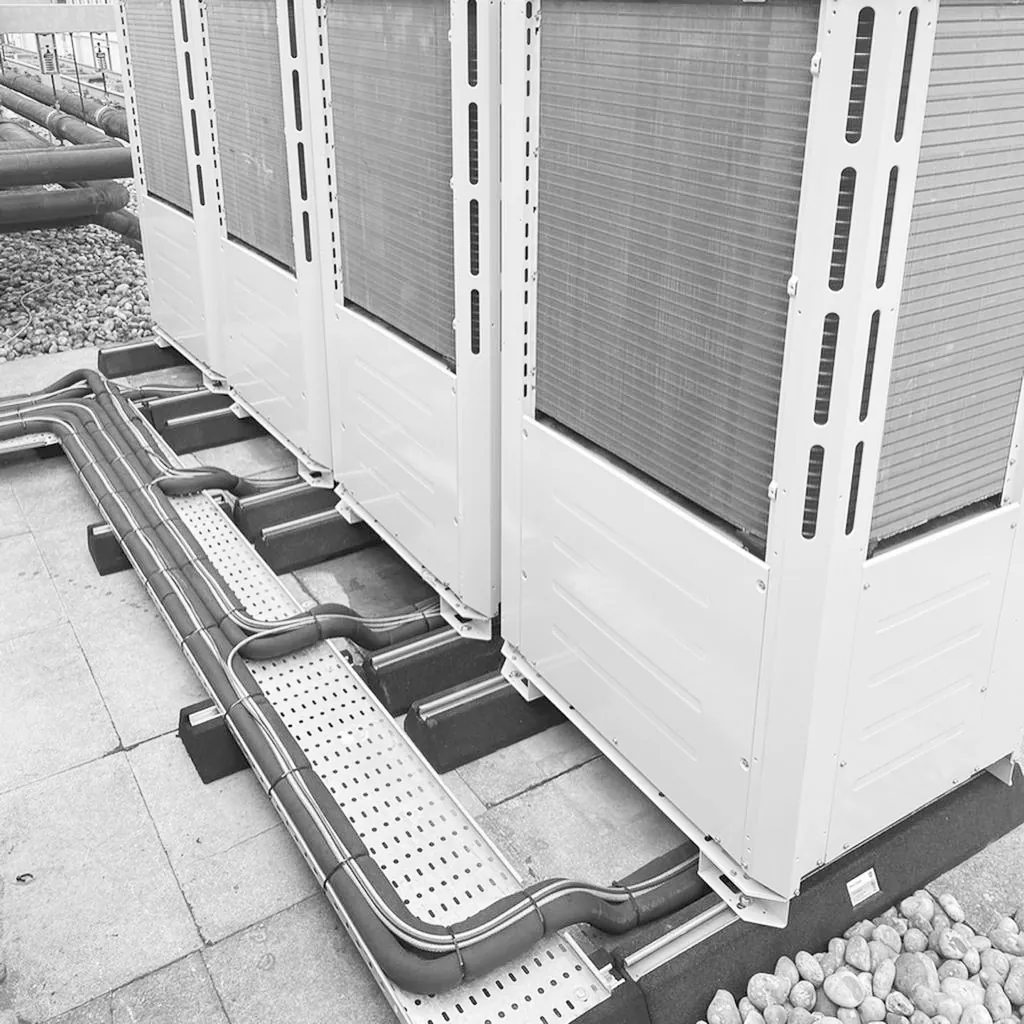 Condenser units on a roof with pipework run on support rails